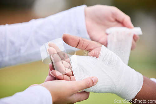 Image of Sports, bandage and person with hand injury support, first aid emergency and strain after game, competition or workout. Closeup, accident and medic helping athlete with gauze, wound or anatomy trauma