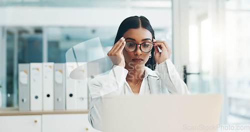 Image of Business woman, glasses and working on laptop in office for planning, reading email and internet research in law firm. Indian lawyer, attorney and focus at computer to start legal analysis in company