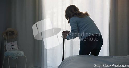 Image of Balance, medical and window with old woman and walking stick in bedroom for wellness, retirement and healthcare. Depression, mental health and nursing home with patient with a disability for support