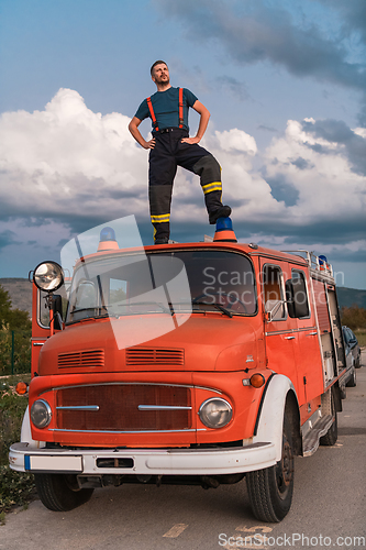 Image of The firefighter standing confidently on the fire truck, ready to respond to any emergency.