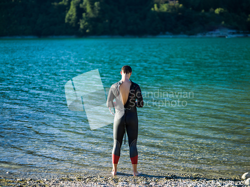 Image of A triathlon swimmer preparing for a river training to gear up for a marathon