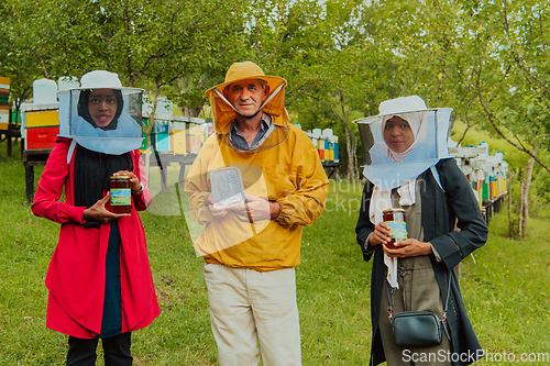 Image of Portrait of Arab investors with a beekeeper in a large honey production farm