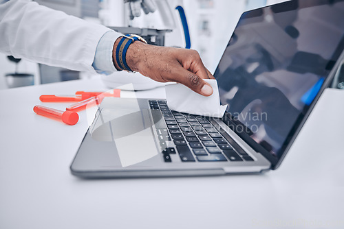 Image of Man, hands and scientist cleaning laptop in disinfection, bacteria or germ removal in the laboratory. Closeup of male person wiping computer keypad for clean hygiene, sanitizing or health and safety