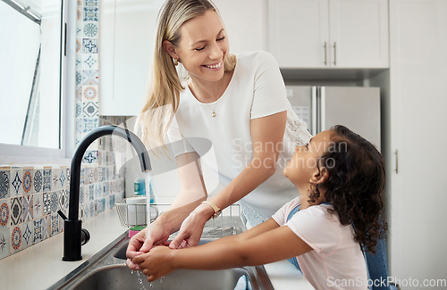 Image of Mother, child and wash hands in home kitchen for good hygiene, health and wellness. Happy woman helping kid or daughter while learning skin care, cleaning and safety for germs or dirt at family house