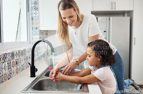 Image of Mother, child and washing hands at kitchen sink at home for good hygiene, health and wellness. A woman and kid or daughter learning skin care, cleaning and safety from germs or dirt at family house