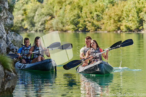 Image of A group of friends enjoying having fun and kayaking while exploring the calm river, surrounding forest and large natural river canyons