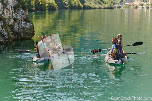 Image of A group of friends enjoying having fun and kayaking while exploring the calm river, surrounding forest and large natural river canyons