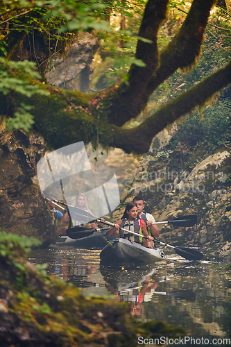 Image of A group of friends enjoying having fun and kayaking while exploring the calm river, surrounding forest and large natural river canyons