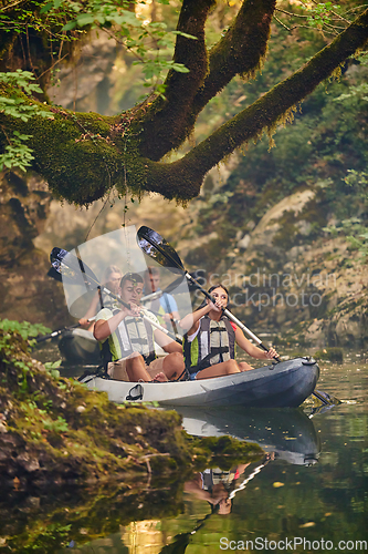 Image of A group of friends enjoying having fun and kayaking while exploring the calm river, surrounding forest and large natural river canyons