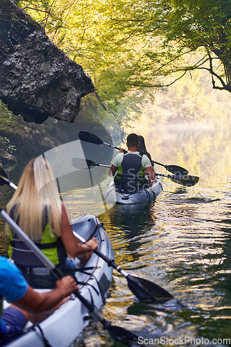 Image of A group of friends enjoying having fun and kayaking while exploring the calm river, surrounding forest and large natural river canyons