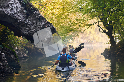 Image of A group of friends enjoying having fun and kayaking while exploring the calm river, surrounding forest and large natural river canyons