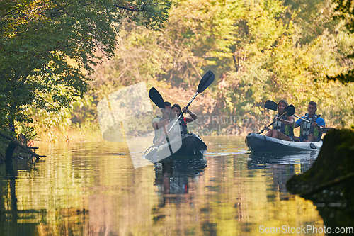 Image of A group of friends enjoying having fun and kayaking while exploring the calm river, surrounding forest and large natural river canyons