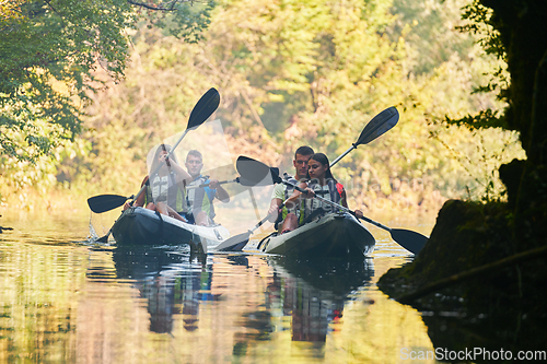 Image of A group of friends enjoying having fun and kayaking while exploring the calm river, surrounding forest and large natural river canyons