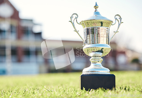 Image of Trophy on grass, champion and prize with fitness outdoor, competition and game with mockup space. Award on pitch, reward and tournament cup with goals, stadium and sports ground field with winner