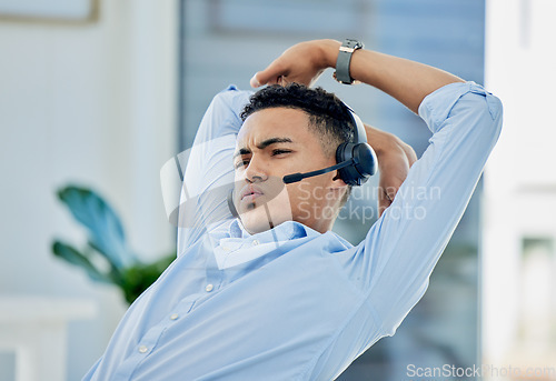 Image of Tired, stretching and man in call center with stress for telemarketing, customer service and sales consulting. Lazy, uncomfortable and male agent on a break for burnout, fatigue or bored at help desk