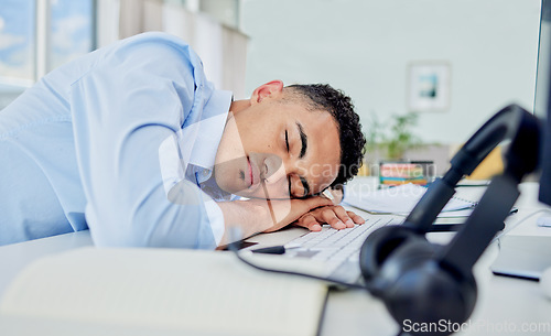 Image of Call center, tired and man sleeping on desk in a workplace, employee and insomnia with mental health. Business, fatigue and consultant with burnout, tech and exhausted with nap at work with stress