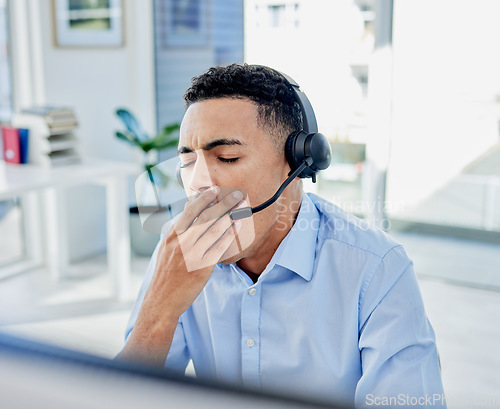 Image of Tired, yawn and a man in a call center for customer service or support while working online at his desk. Contact us, consulting and crm with an exhausted young male employee in a telemarketing office