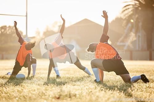 Image of Rugby, club and team stretching at training for match or competition in the morning doing warm up exercise on grass. Wellness, teamwork and group of players workout together in professional sports