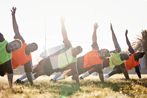 Image of Rugby, fitness and team at training for competition or morning match doing warm up exercise on grass. Wellness, teamwork and group of players stretching or workout together in professional sports