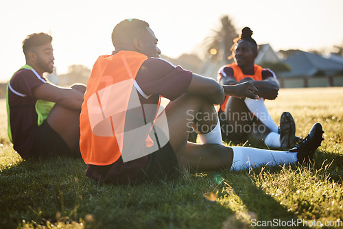 Image of Rugby, team and men relax on field outdoor, talking and communication at sunrise in the morning. Sports, athlete group and players sitting on grass after exercise, training or friends workout in game