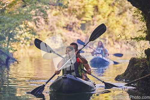 Image of A group of friends enjoying having fun and kayaking while exploring the calm river, surrounding forest and large natural river canyons