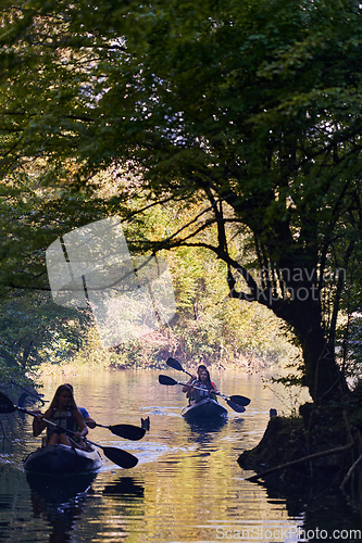 Image of A group of friends enjoying having fun and kayaking while exploring the calm river, surrounding forest and large natural river canyons