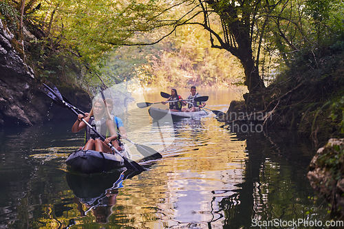 Image of A group of friends enjoying having fun and kayaking while exploring the calm river, surrounding forest and large natural river canyons