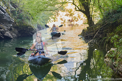 Image of A group of friends enjoying having fun and kayaking while exploring the calm river, surrounding forest and large natural river canyons