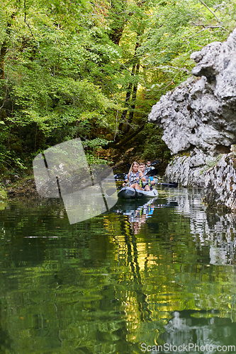 Image of A group of friends enjoying having fun and kayaking while exploring the calm river, surrounding forest and large natural river canyons