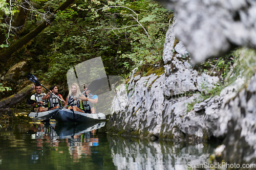 Image of A young couple enjoying an idyllic kayak ride in the middle of a beautiful river surrounded by forest greenery