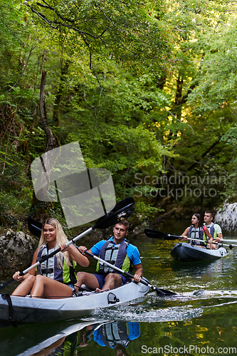 Image of A group of friends enjoying having fun and kayaking while exploring the calm river, surrounding forest and large natural river canyons