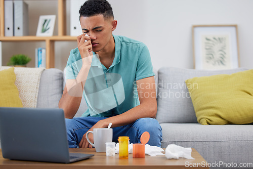 Image of Young man, sofa and sick with virus, laptop and streaming online or research about symptoms, medicine and health. Male person, healthcare and browse on pc with pills, pharmaceutical and drugs for flu