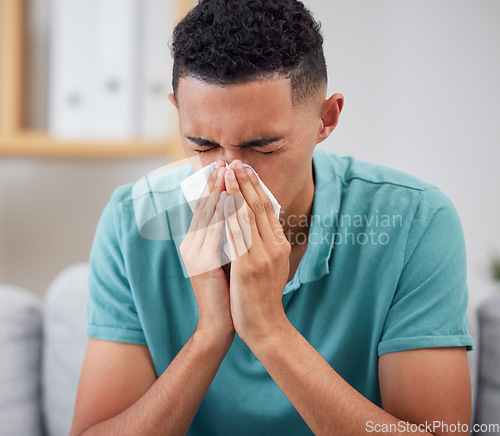 Image of Man blowing nose, sick with virus and health with hayfever, medicine with cold or flu while at home. Young male person, allergy and sinus, healthcare and wellness, infection and illness with bacteria