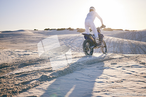 Image of Desert, motorbike and back of sports person travel, transport and driving on challenge adventure, freedom and training. Nature sunset, extreme action and athlete ride motorcycle on sand dunes hill