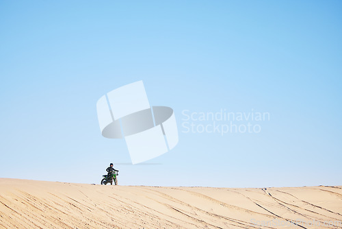 Image of Motorcycle race, desert and sand with space, blue sky background and outdoor for off road challenge in summer. Motorbike, person and dirt trail for performance, power and fast adventure for mockup