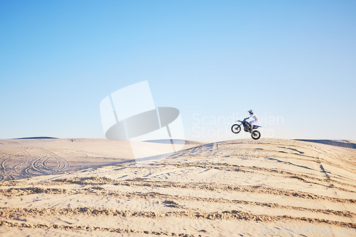 Image of Desert, bike jump or sports person travel, agile and air trick on sand hill adventure, exercise or training. Motorcycle challenge, sky or extreme athlete risk, freestyle competition or skill training