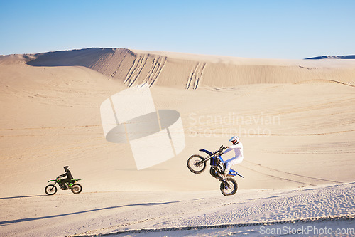 Image of Bike, sand and freedom with people in the desert for adrenaline, adventure or training in nature. Moto, sports and balance with friends on dirt in summer for a race competition or training on space