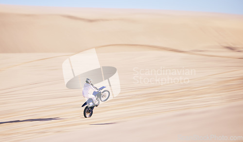 Image of Bike, sand and fitness with a man in the desert for adrenaline, adventure or training in nature. Motorcycle, speed and balance with an athlete riding a sports vehicle on space in summer for freedom