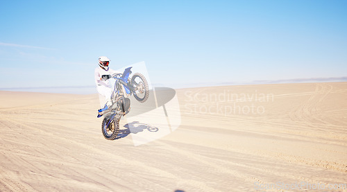 Image of Desert, motorbike and sports person travel, journey and driving on off road adventure, freedom and balance on bike. Motorcycle, extreme action or athlete driver, racer or rider training on sand dunes