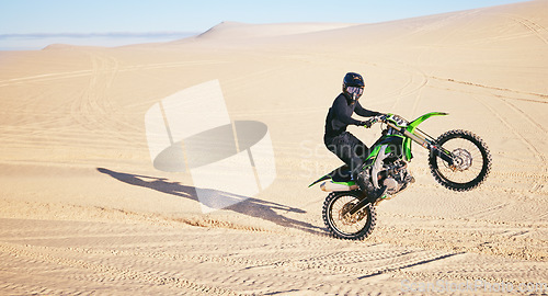 Image of Motorcycle, sand and space with a man in the desert for adrenaline, adventure or training in nature. Energy, summer and balance with an athlete riding a bike for sports training in a remote location