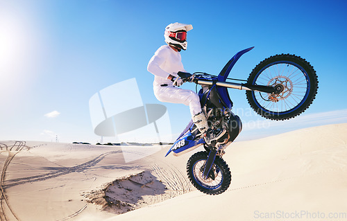 Image of Jump, sports and man on motorcycle on sand for adrenaline, adventure and freedom in desert. Action, extreme motorbike and male person on bike on dunes for training, exercise and race or challenge