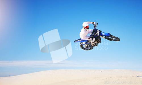 Image of Race, motorbike jump and person in desert, action and extreme sport with speed outdoor and mockup space. Adventure, fitness and blue sky, motorcycle jump stunt and freedom, challenge and performance