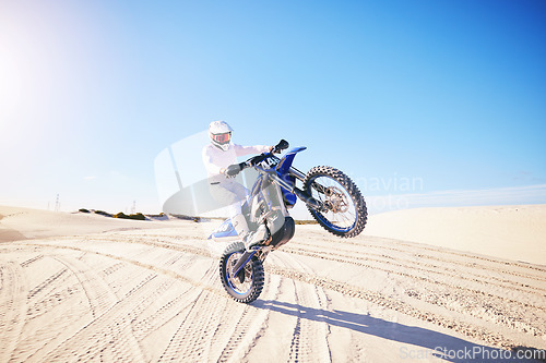 Image of Sand, motorbike balance and sports person doing trick, skill or stunt on off road challenge, training and freestyle competition. Driving motorcycle, nature cycling or athlete driver on desert dunes