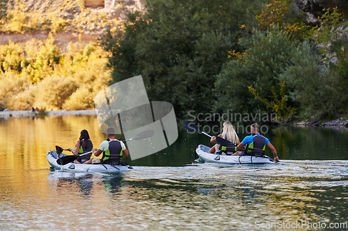 Image of A group of friends enjoying having fun and kayaking while exploring the calm river, surrounding forest and large natural river canyons