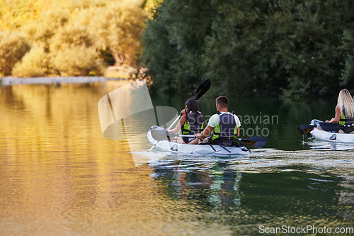 Image of A group of friends enjoying having fun and kayaking while exploring the calm river, surrounding forest and large natural river canyons