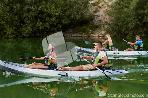 Image of A group of friends enjoying having fun and kayaking while exploring the calm river, surrounding forest and large natural river canyons