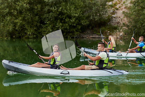 Image of A group of friends enjoying having fun and kayaking while exploring the calm river, surrounding forest and large natural river canyons