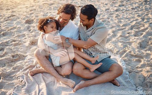 Image of Gay father, play and girl at beach with love, tickling or hug for vacation, laughing or outdoor in sunshine. LGBTQ parents, young kid and adoption with family, holiday or comic conversation in summer