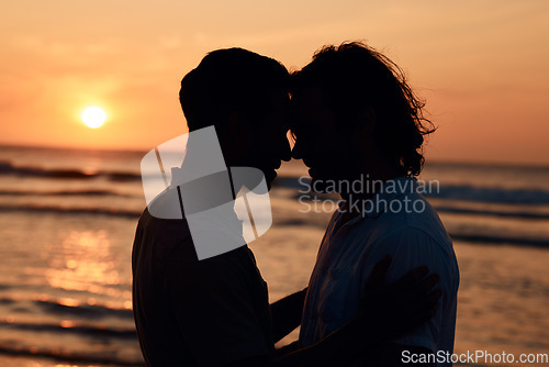 Image of Silhouette, kiss and gay couple on beach, sunset and love on summer island vacation together in Thailand. Sunshine, ocean and romance, lgbt men in nature and fun holiday with pride, sea and waves.