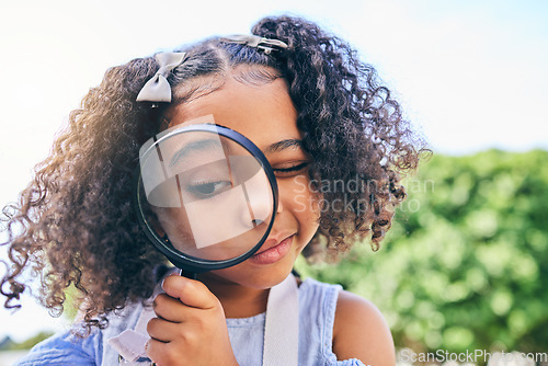 Image of Girl child, magnifying glass and inspection in garden, backyard or park in science, study or outdoor. Young female kid, lens and zoom for nature, search or check for plant, leaves or growth in summer